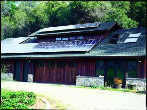 The roof of the barn building at the garden and orchard site supports an extensive photovoltaic array. Inside, a room is dedicated to storing the batteries and electrical panels that monitor and control the system. A portion of the barn is a greenhouse for starting seedlings for the garden.
